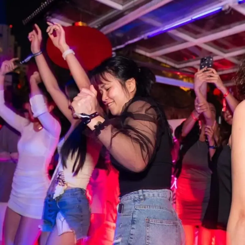 Adult women dancing together inside a Bangkok nightclub